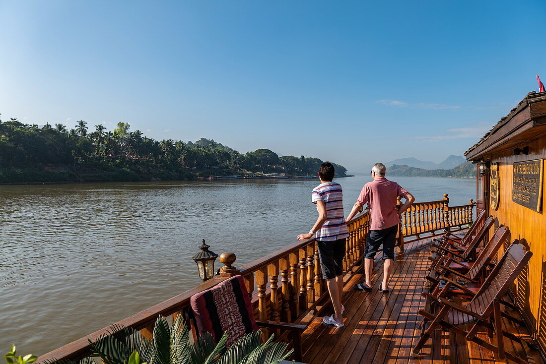 Paar an Reeling von Flusskreuzfahrtschiff Mekong Sun auf Fluss Mekong, Luang Prabang, Provinz Luang Prabang, Laos, Asien