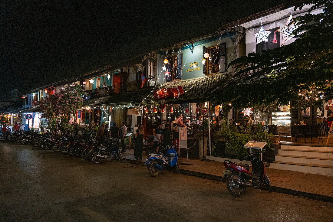 Mopeds stand outside busy restaurant and bar on Sisavangvong Road (the main street), Luang Prabang, Luang Prabang Province, Laos, Asia