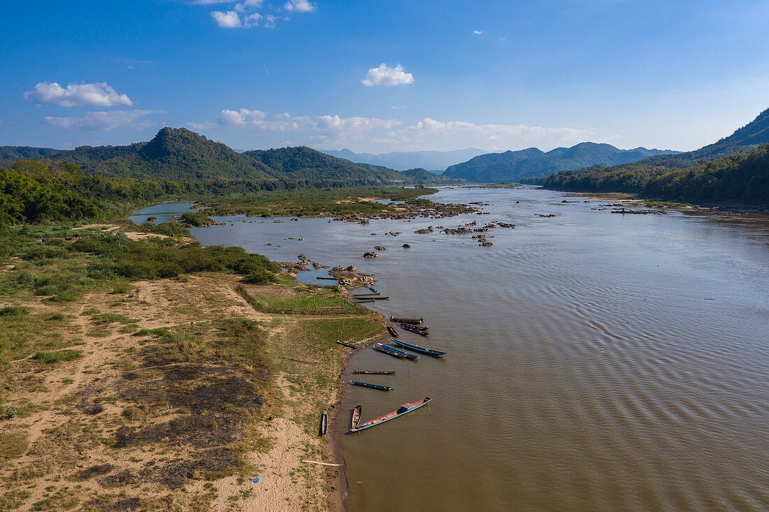 Luftaufnahme von Kanus und Longtail-Booten am Ufer vom Fluss Mekong, Pak Ou, Provinz Luang Prabang, Laos, Asien