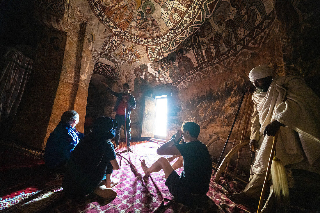Tourists admiring fresco and paintings inside Abuna Yemata Guh church, Gheralta Mountains, Tigray Region, Ethiopia, Africa