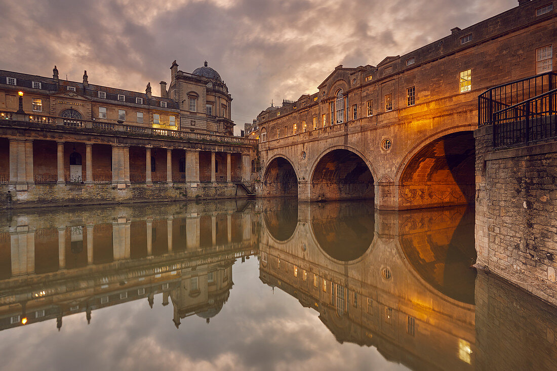 Ein Blick in die Dämmerung auf die einzigartige Pulteney-Brücke aus dem 18. Jahrhundert, die den Fluss Avon überspannt, im Herzen von Bath, UNESCO-Weltkulturerbe, Somerset, England, Vereinigtes Königreich, Europa