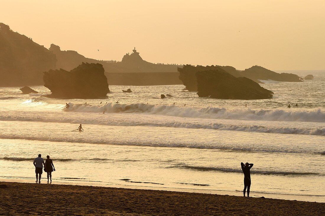 Frankreich, Pyrenäen Atlantiques, Baskenland, Biarritz, Surfer am Grande Plage (größter Strand der Stadt) und Rocher de la Vierge (Jungfernfelsen) im Hintergrund