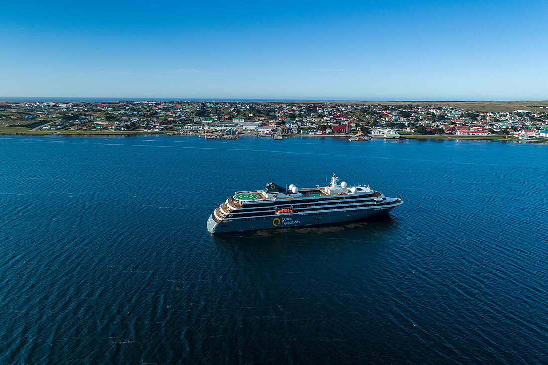 Luftaufnahme von Expeditions Kreuzfahrtschiff World Explorer (nicko cruises) mit Stadt dahinter, Stanley, Falklandinseln, Britisches Überseegebiet, Südamerika