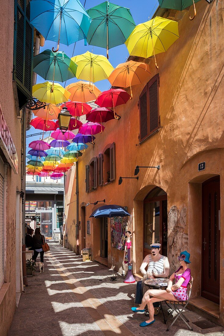 Frankreich, Var, , Arts District, Pappmaché Skulptur der Künstlerin Liliana Anic und bunte Regenschirme hängen über der Rue du Safranier