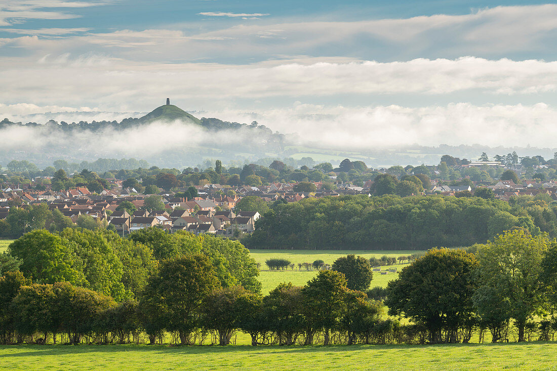 View across the town of Street towards Glastonbury Tor on a misty autumn morning, Somerset, England, United Kingdom, Europe