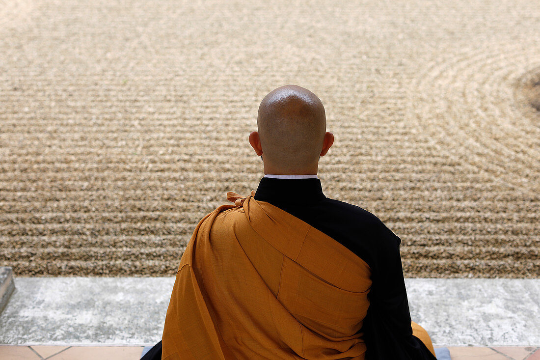 Zen-buddhistischer Meister, der Zazen (Meditation) im Zen-Garten der Orval Trappist Abbey, Belgien, Europa, praktiziert