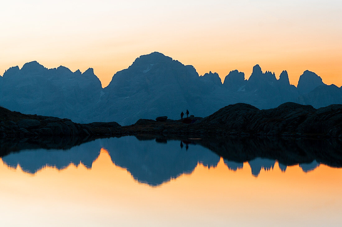 Brenta Dolomites Berge reflektiert in unberührtem Wasser des Lago Nero di Cornisello bei Sonnenaufgang, Trentino-Südtirol, Italien, Europa