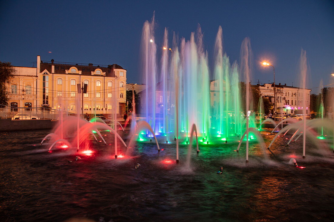 Beleuchteter Musikbrunnen entlang Promenade am Ufer von Fluss Wolga in der Abenddämmerung, Astrachan, Bezirk Astrachan, Russland, Europa