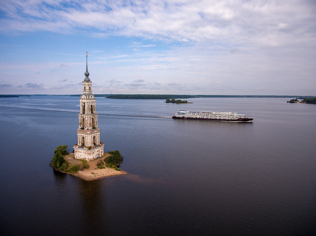 Luftaufnahme von Flusskreuzfahrtschiff Excellence Katharina (ehemals MS General Lavrinenkov) bei Vorbeifahrt am Kalyazin-Glockenturm im Fluss Wolga (die ist alles, was von der Altstadt von Kalyazin nach der Flutung des Uglich-Stausees übrig geblieben ist), Kalyazin, Bezirk Twer, Russland, Europa