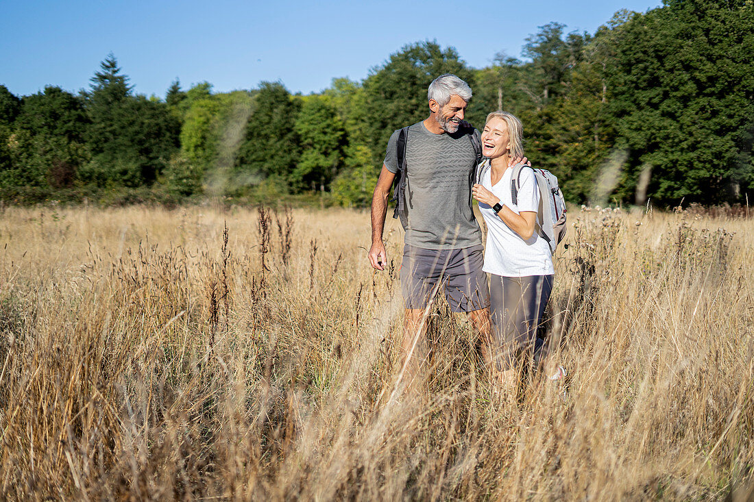 Lächelndes reifes Paar, das im Wald wandert