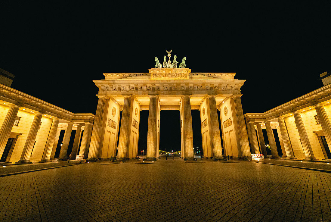 Flachwinkelansicht des beleuchteten Brandenburger Tors bei Nacht, Berlin