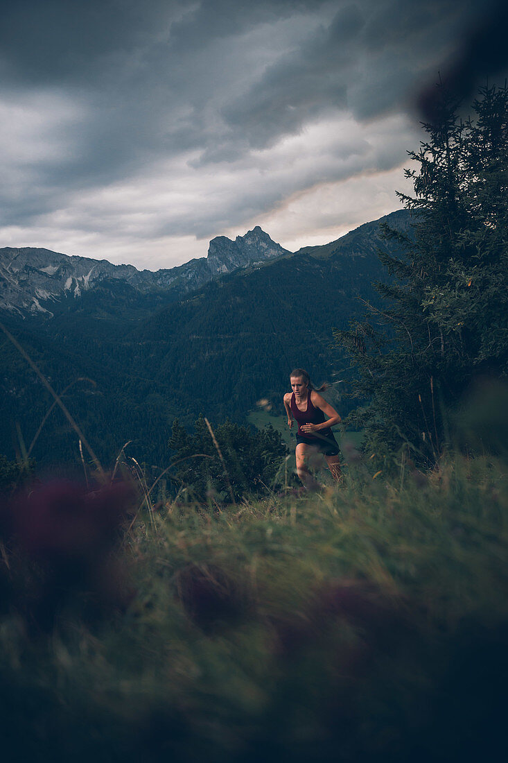 Junge Frau läuft bei Abendstimmung am Falkenstein, Allgäu, Bayern, Deutschland