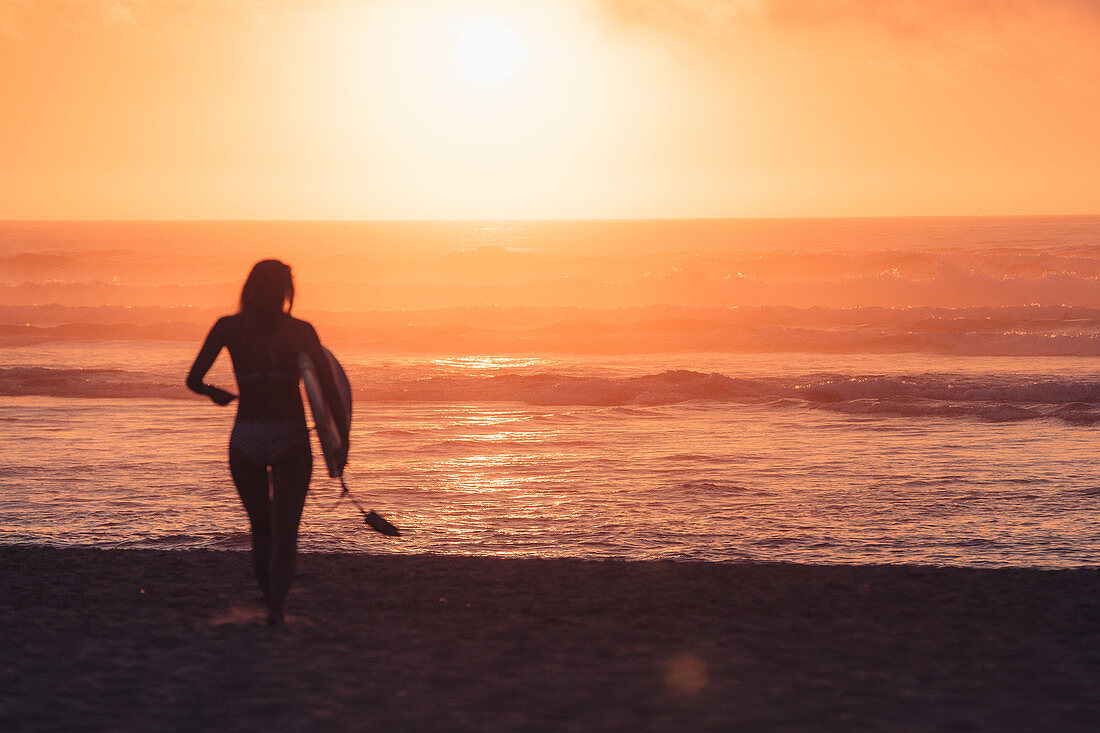 Surfer runs to the sea in sunset, Portugal, surfing, vacation