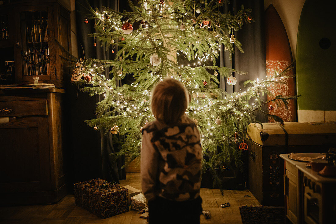 Kleiner Junge steht vorm Christbaum