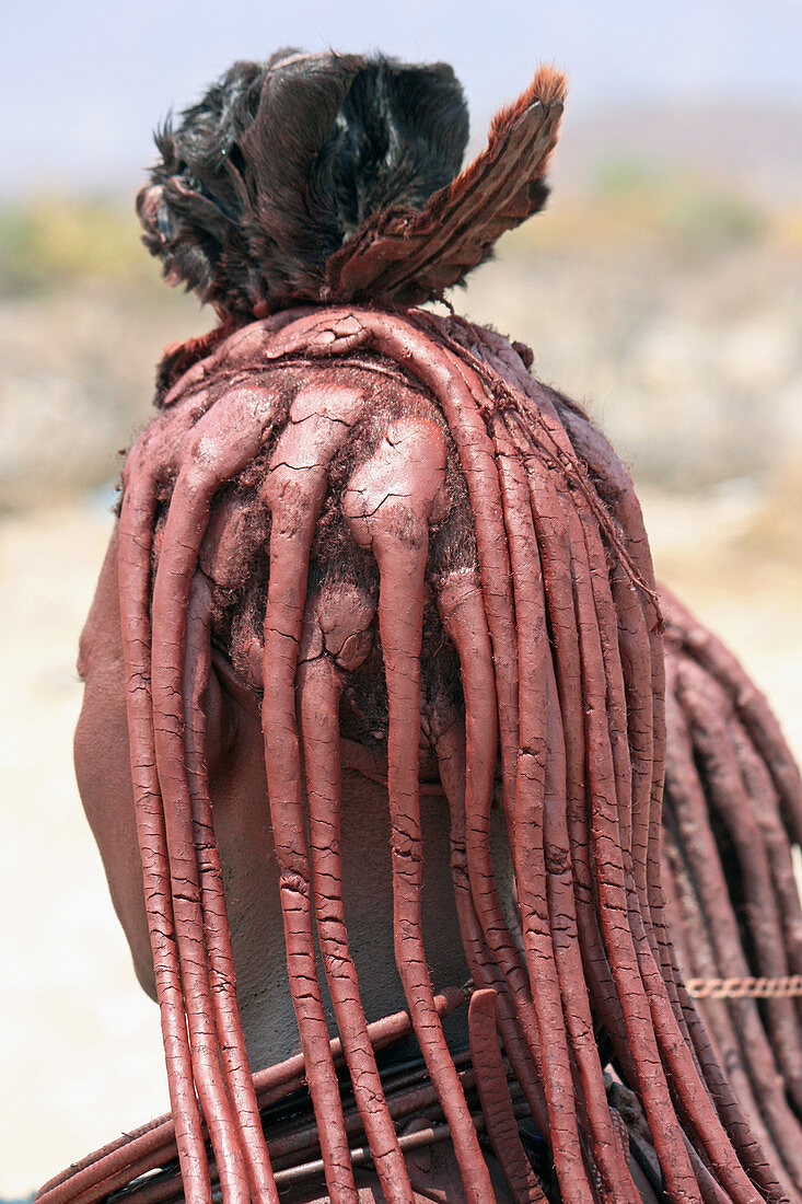 Angola; southern part of Namibe Province; Muhimba woman with traditional hair styling; Strands of hair stuck together with red earth and fluffy fur