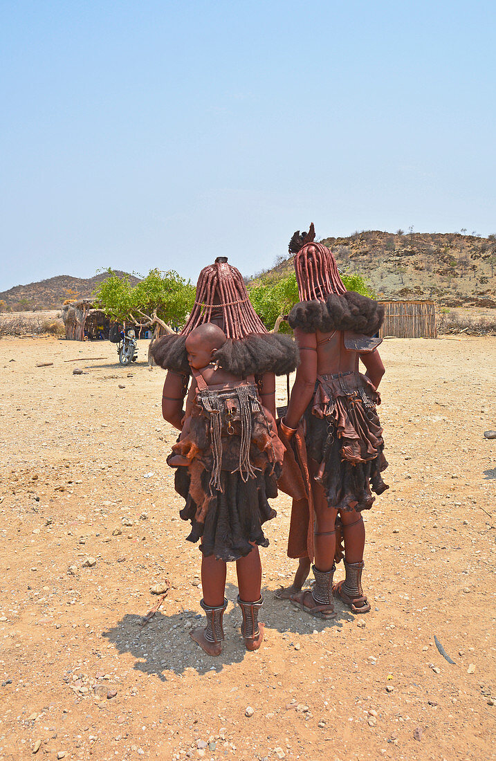 Angola; im südlichen Teil der Provinz Namibe; zwei Muhimba Frauen mit ihren Kindern; bekleidet mit Lederschürzen; traditionelles Haarstyling