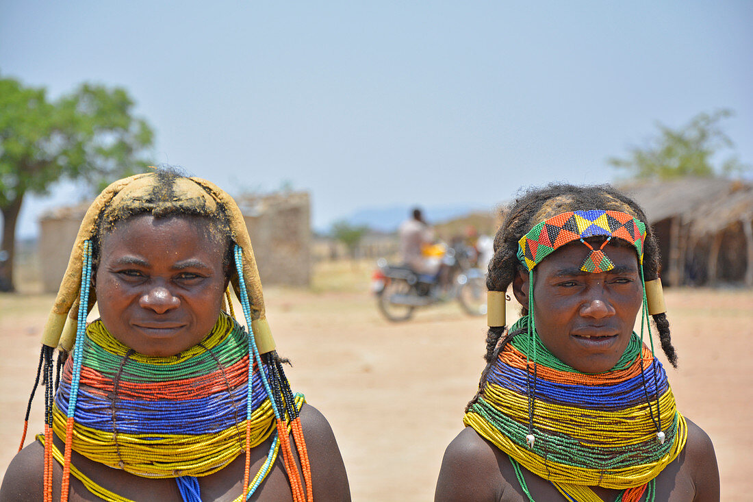 Angola; Huila Province; small village near Chibia; two Muhila women in the market square; typical necklace made of pearl necklaces; Hair fixed with ocher earth
