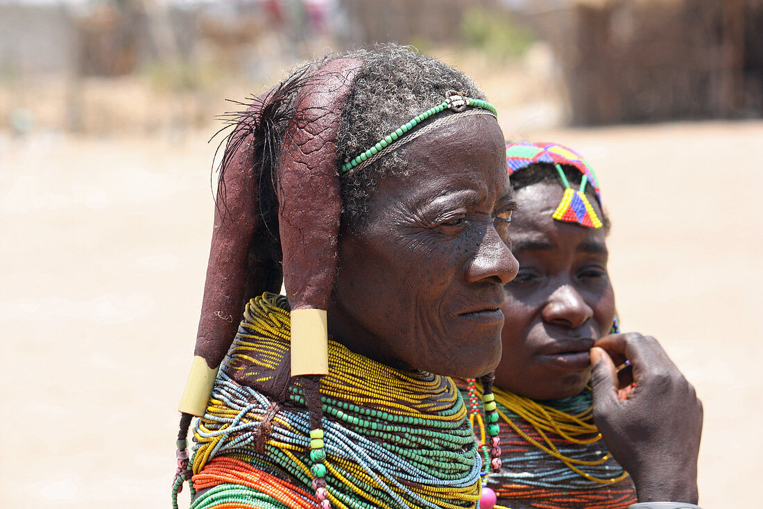 Angola; Provinz Huila; kleines Dorf in der Umgebung von Chibia; Muhila Frauen mit typischem Hals- und Kopfschmuck; Haarbüschel mit Lehm umhüllt und fixiert; massiver Halsreif aus Perlenketten und Erde