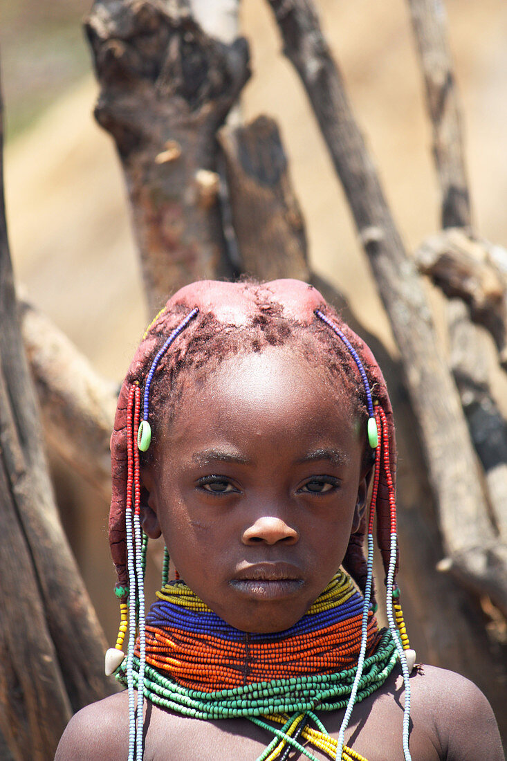 Angola; Provinz Huila; kleines Dorf in der Umgebung von Chibia; Muhila Mädchen mit typischem Hals- und Kopfschmuck; Haarbüschel mit Lehm umhüllt und fixiert; Halsreif aus Perlen und Erde