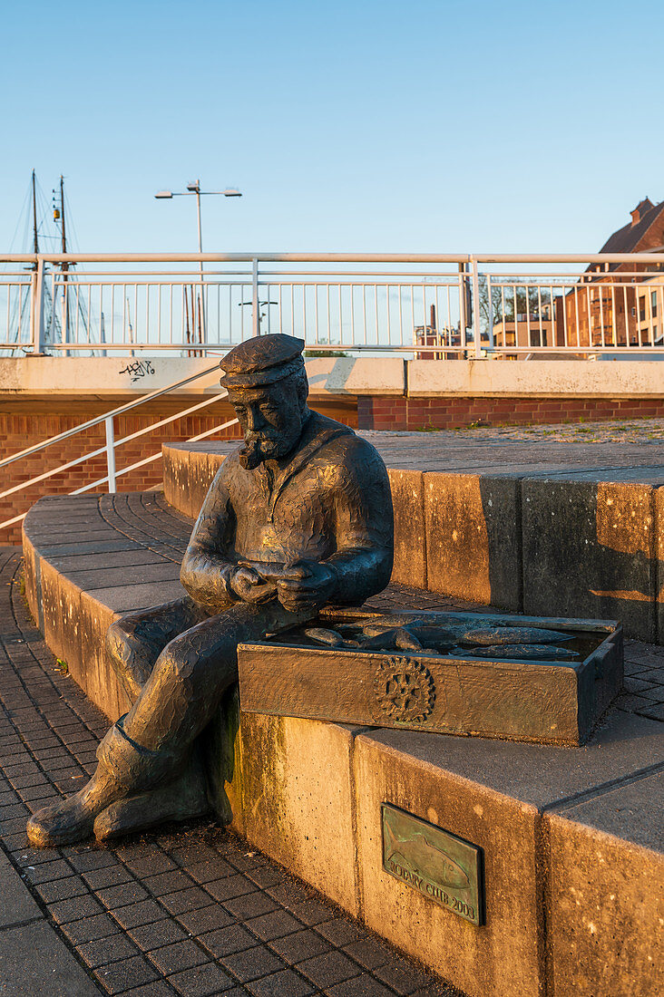 The seated fisherman (sculpture) in Kappeln in the morning, Kappeln, Schlei, fishing, Schleswig-Holstein, Germany
