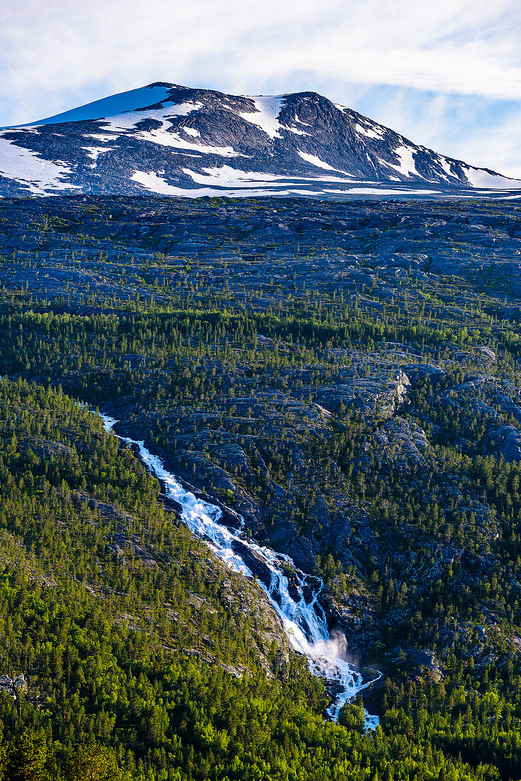 Fasserfall und schneebedeckter Berg an der E 6 Saltfjell, Norwegen