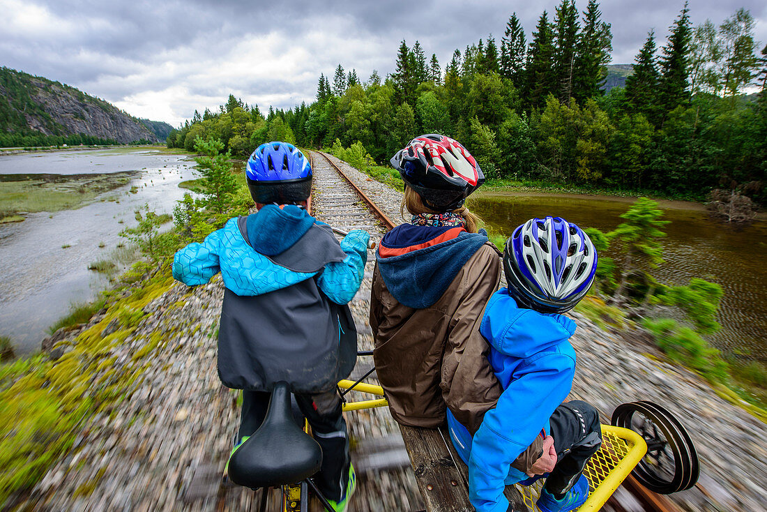 Familie beim Draisine fahren am Campingplatz von Namsos, Norwegen