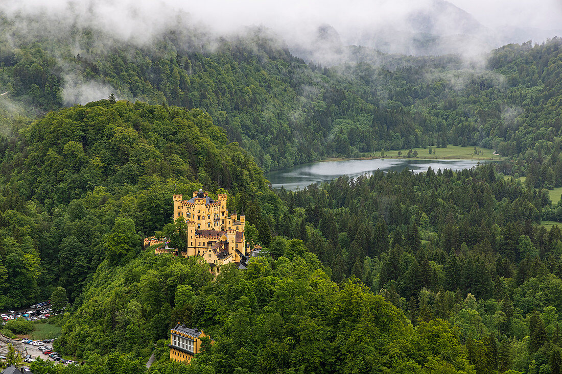 Blick auf Schloss Hohenschwangau und Umgebung mit tiefen Wolken, Schwangau, Oberbayern, Deutschland