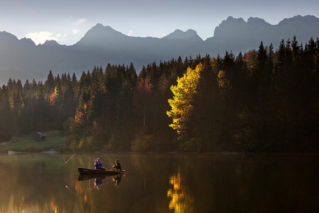 Angler im Ruderboot auf dem Geroldsee im Herbst, Blick zum Karwendel, Werdenfelser Land, Bayern, Deutschland