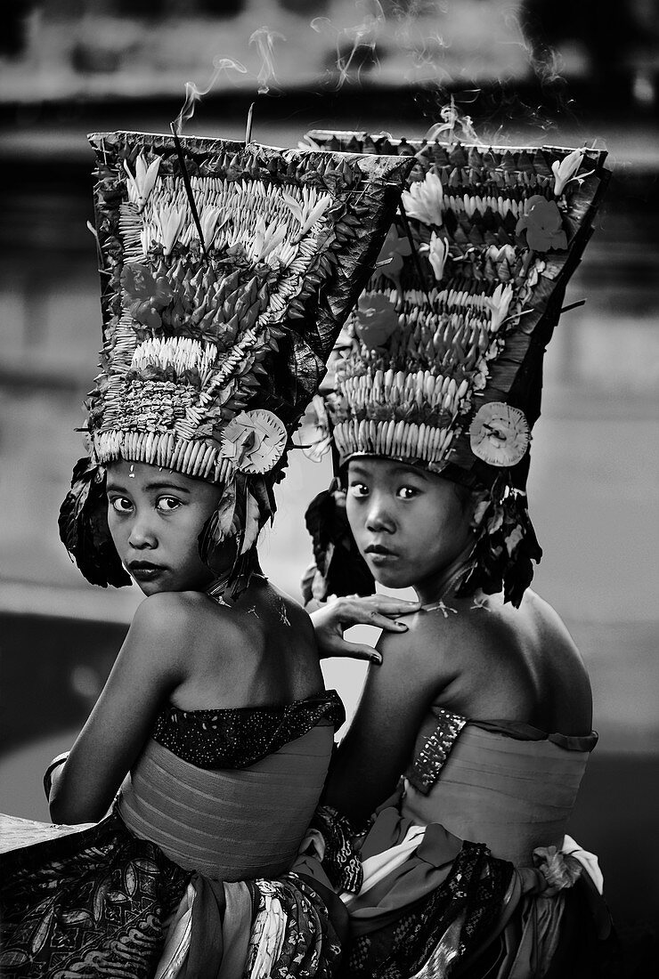 Zwei balinesische Mädchen in Tracht auf hinduistischem Tempelgelände während des Festivals von Galungan und Kuningan, Karangasem, Bali, Indonesien