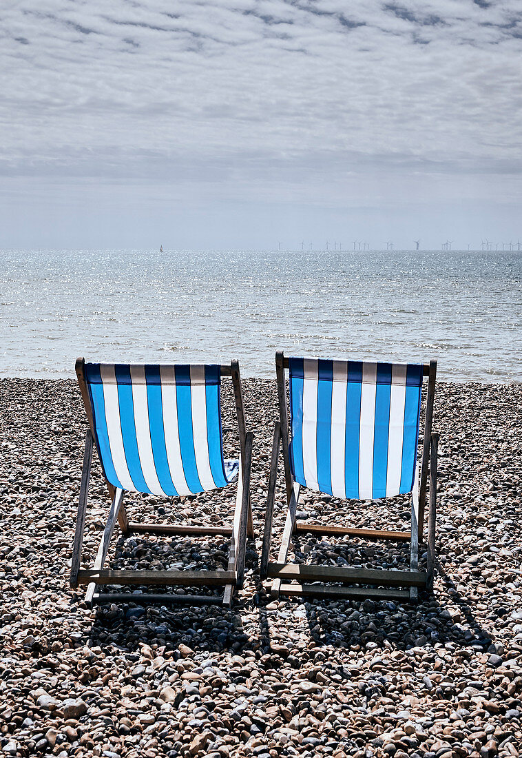 Liegestühle am Strand von Brighton an einem Frühlingstag, Brighton, East Sussex, UK