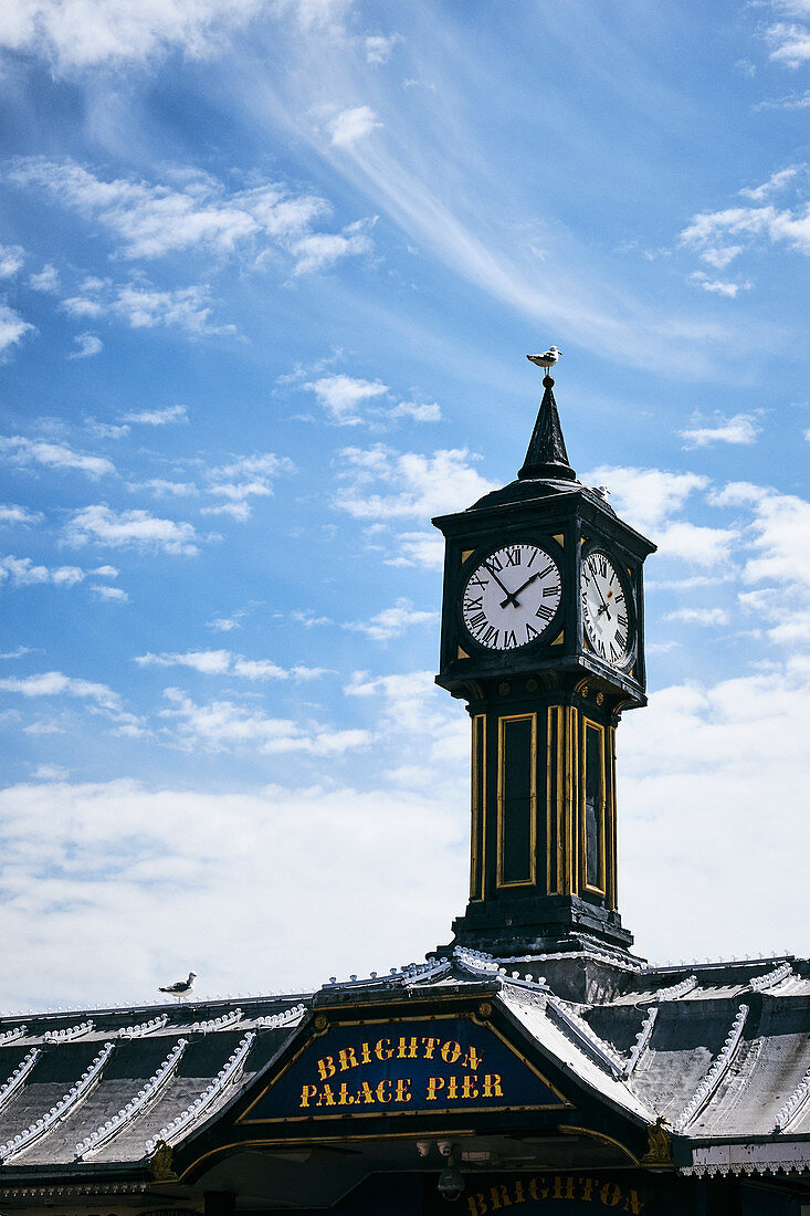 The clock tower on the Brighton Palace Pier against a spring sky, Brighton, East Sussex, UK.