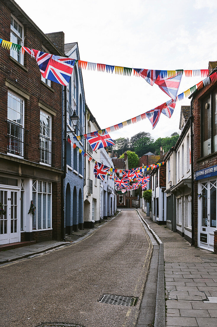 Straßenansicht von Gebäuden in der Courthouse Street, mit Wimpeln geschmückt anlässlich des Jack-in-the-Green-Festivals in der Altstadt von Hastings, East Sussex, Großbritannien, UK