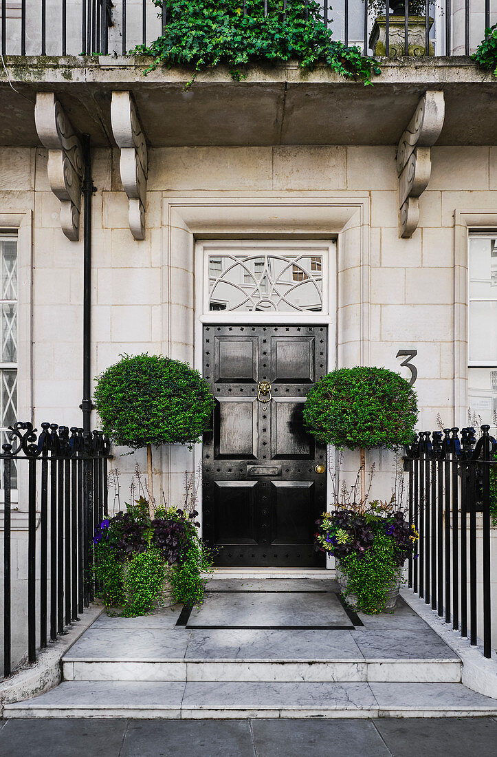 A doorway of a private residence with flower boxes in Kensington, London UK.