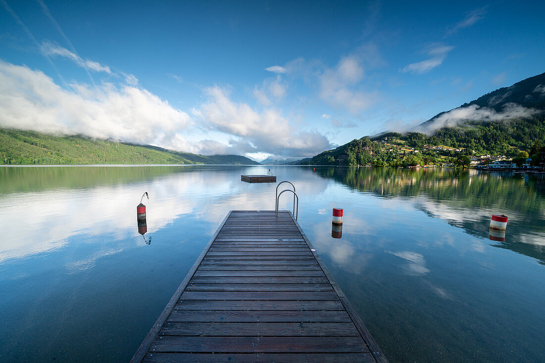 Blick über den Millstätter See vom Badestrand am Ostufer auf alpine Gebirgs- und Kulturlandschaft, Döbriach, Kärnten; Östereich, Europa.