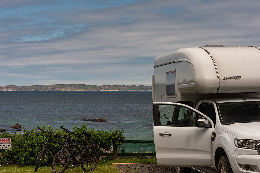 Teilansicht eines Vans und Fahrräder mit Blick auf das  Meer, Ballycastle, Nordirland