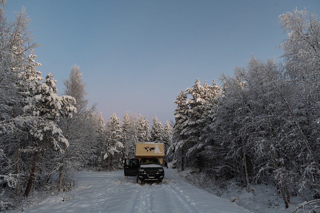 Van im tiefen Schnee auf einem einsamen Platz im Wald, Bergnäsviken, Lappland, Schweden