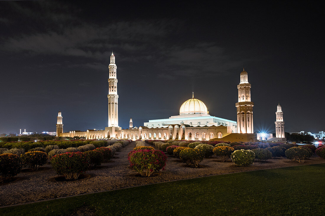 Nachtansicht der beleuchteten Sultan-Qabus-Moschee und des Oleanderfeldes im Vordergrund, Naher Osten