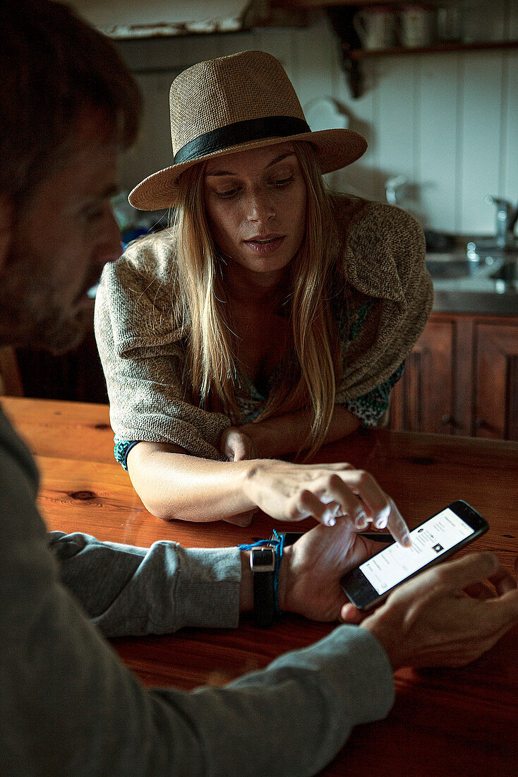 Couple using smartphone at home