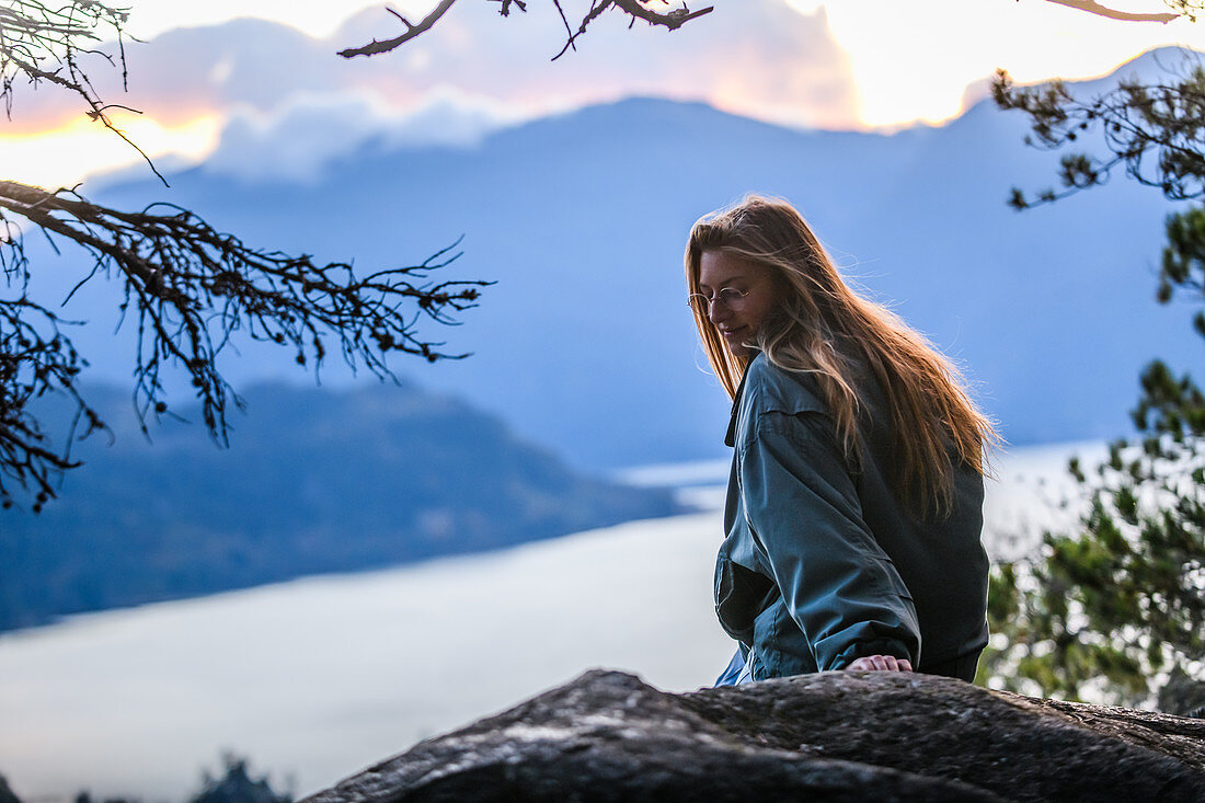 Canada, British Columbia, Squamish, Young woman sitting on rock