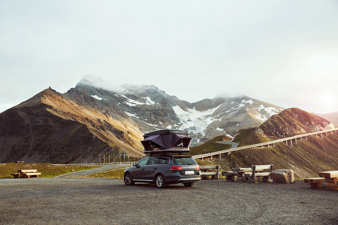 Italien, Österreich, Auto mit Zelt auf dem Dach in Berglandschaft