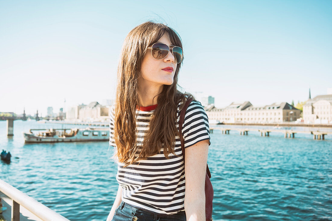 Germany, Berlin, Portrait of young woman by river