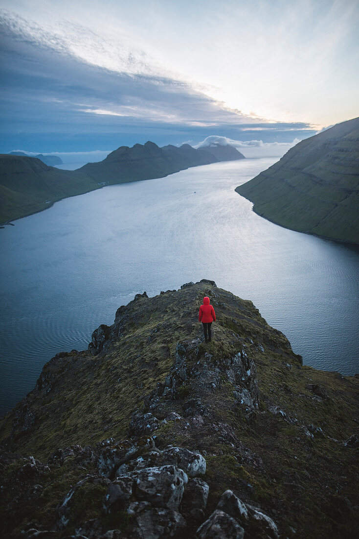 Dänemark, Färöer, Klaksvik, Frau, die auf dem Berg Klakkur über dem Meer steht und die Aussicht betrachtet