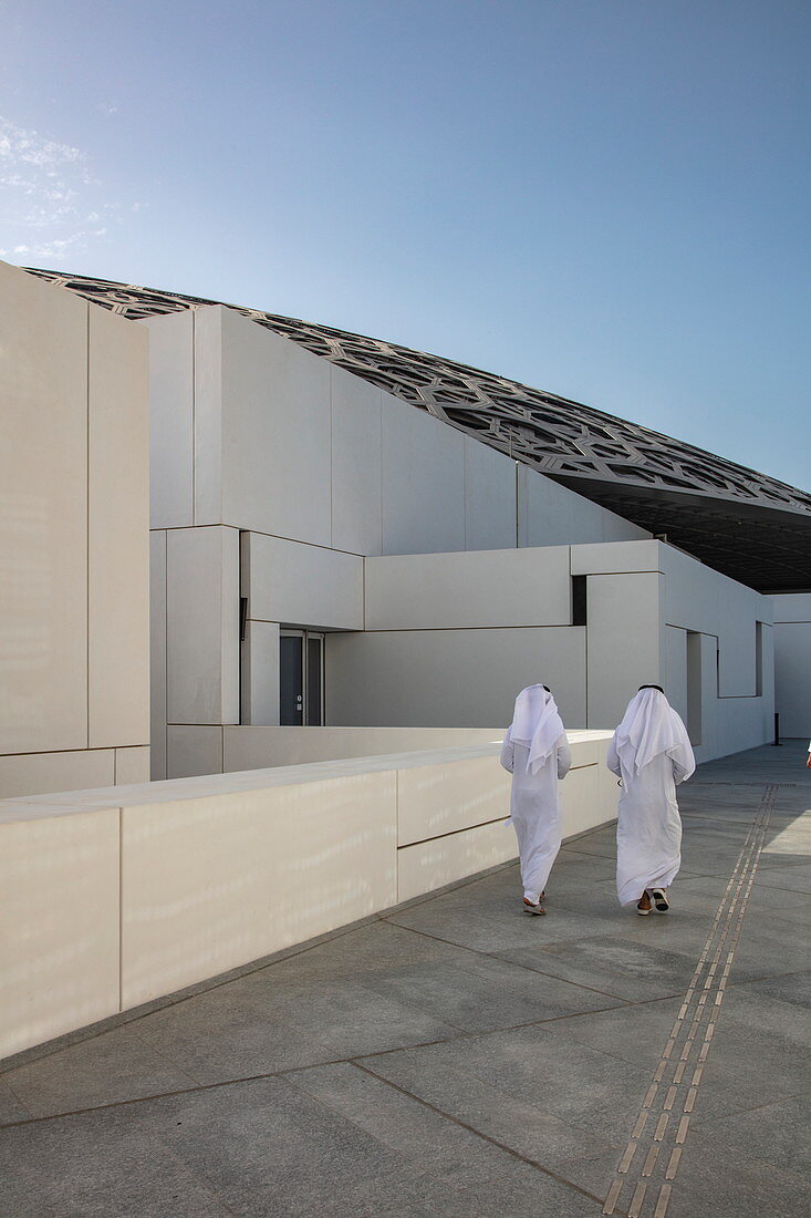 Zwei arabische Männer gehen laufen entlang Weg Außerhalb des Louvre Abu Dhabi Museum, Abu Dhabi, Vereinigte Arabische Emirate, Naher Osten