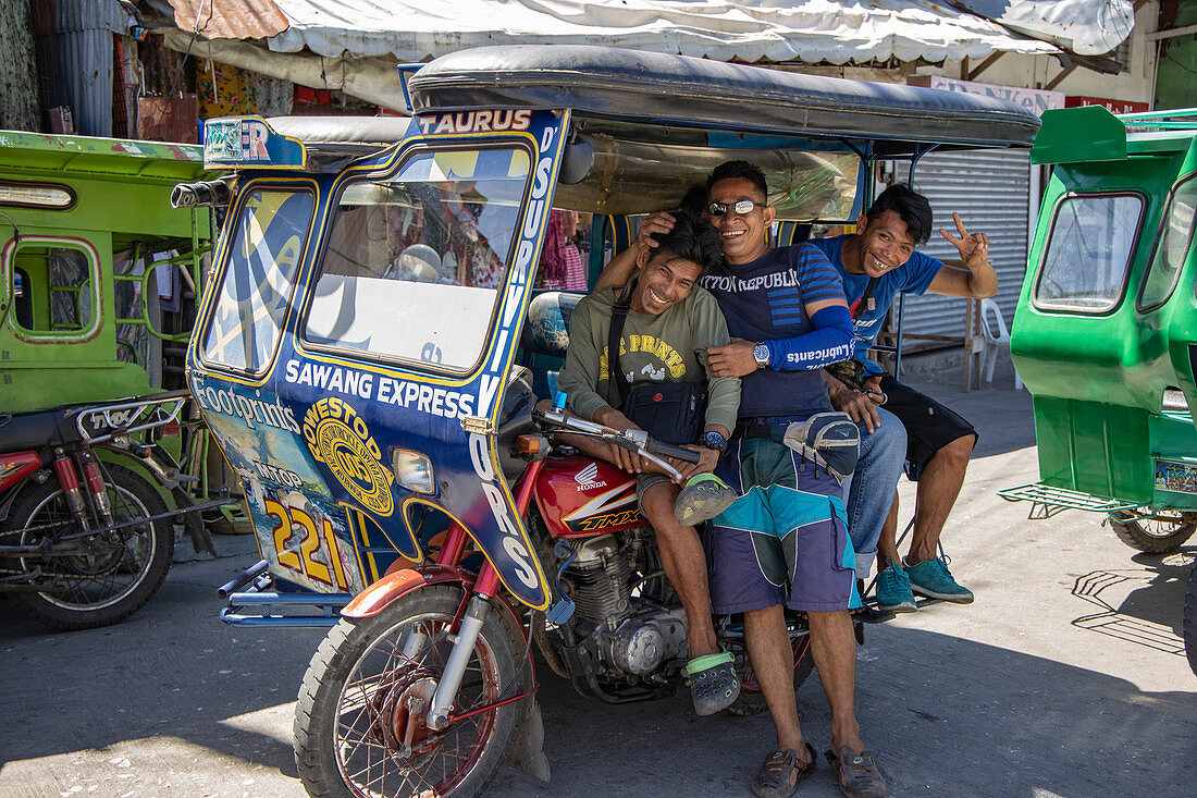 Drei glückliche Männer warten vor einer dreirädrigen Rikscha in Romblon Town, Barangay I, Romblon, Romblon, Philippinen, Asien