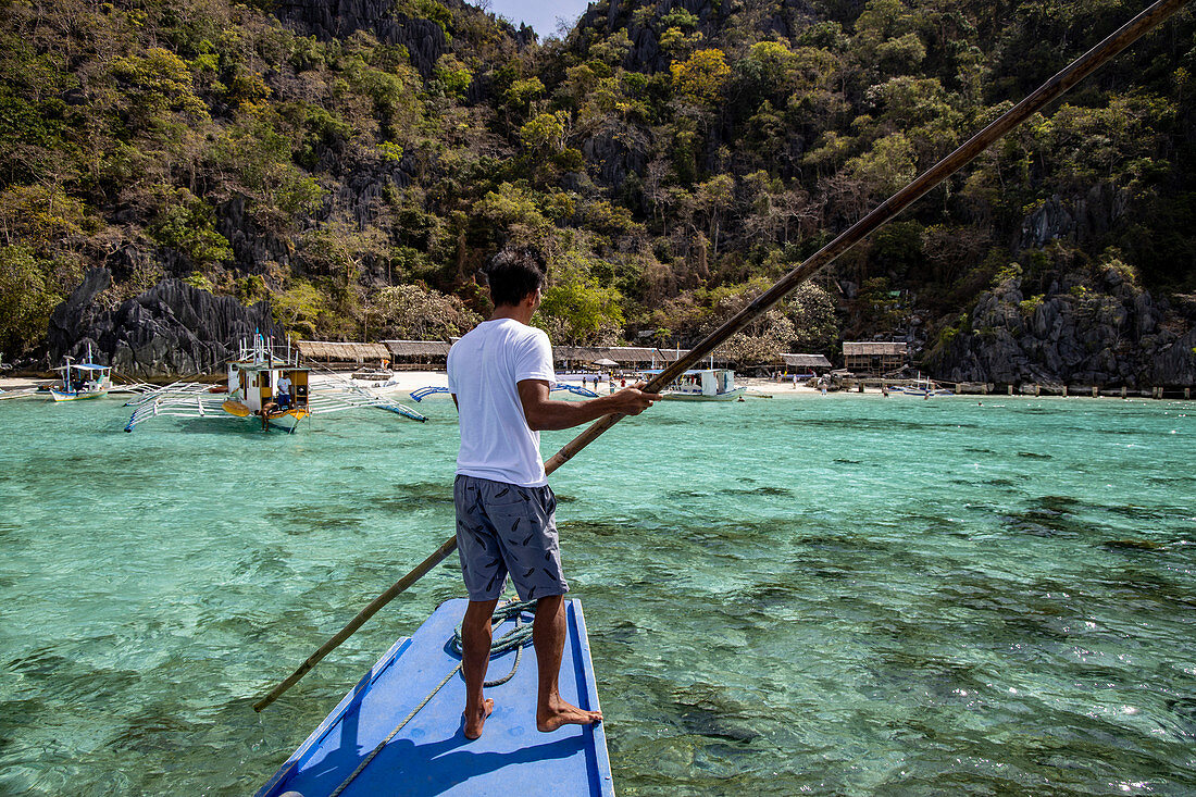 Boatswain on traditional Filipino Banca outrigger canoe at Dicantuman Beach on Coron Island, Banuang Daan, Coron, Palawan, Philippines, Asia