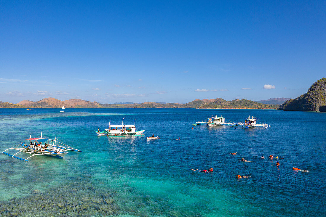 Aerial view of guests enjoying a snorkeling trip at the Skeleton Wreck shipwreck off Coron Island, Banuang Daan, Coron, Palawan, Philippines, Asia