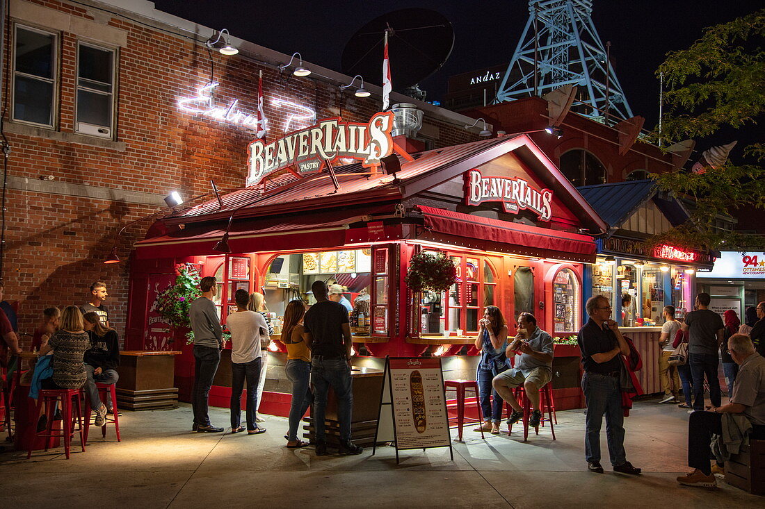 Menschen stehen Schlange für berühmtes BeaverTail-Zimtgebäck in der BeaverTails-Bäckerei bei Nacht, Ottawa, Ontario, Kanada, Nordamerika