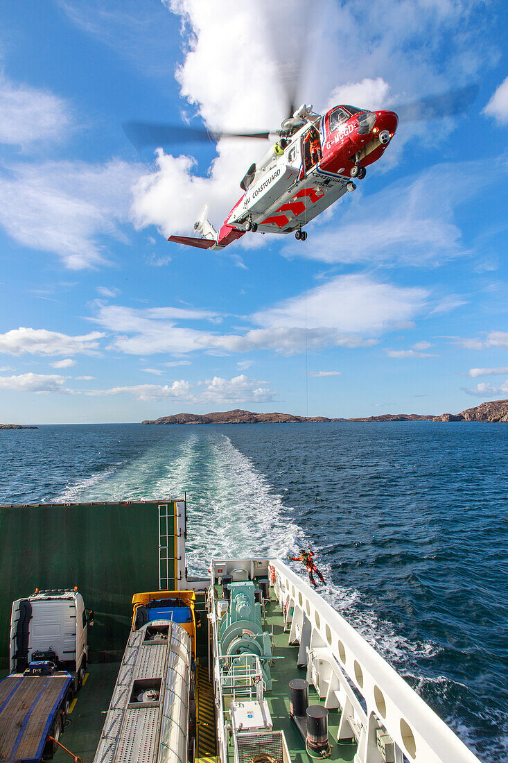 Coastguard Helikopter bei Rettungsübung über der Fähre, Schottland UK