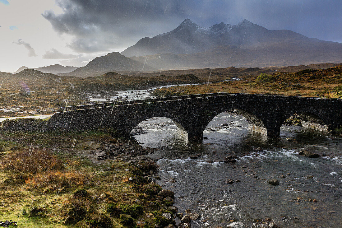Sun and raindrops, historic stone bridge, Sligachan Bridge, Cuilins mountain range, Isle of Skye, Scotland, UK
