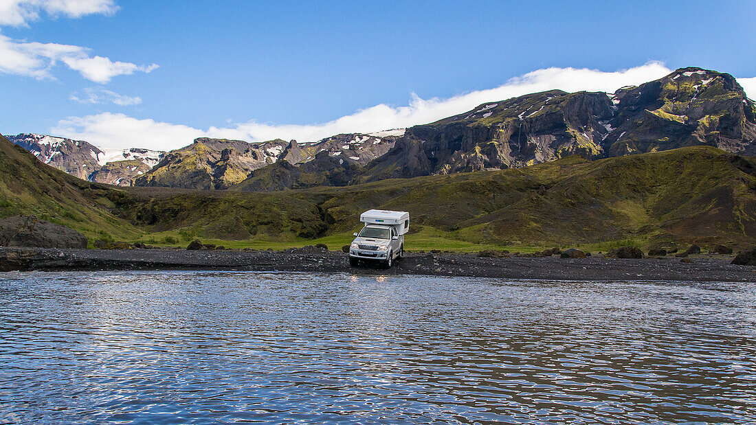 Campers crossing a river in the highlands of Iceland